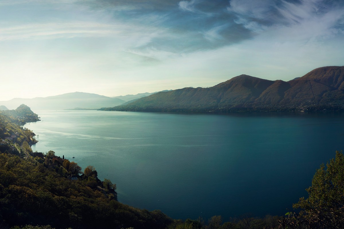 Blue lake surrounded by mountains and trees.